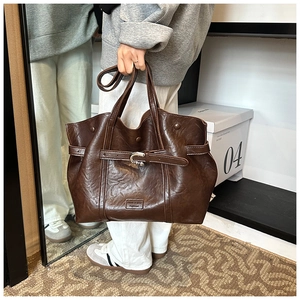 Dettaglio borsa tote in pelle PU marrone scuro con trama vintage e fibbia metallica