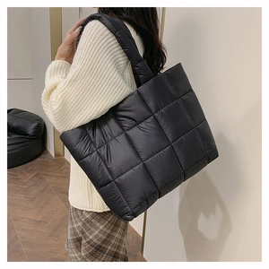 Détail du grand sac cabas noir en nylon matelassé montrant le motif de carrés et les anses