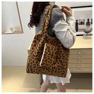 Détail du sac cabas en velours côtelé léopard avec rayures et pochette assortie