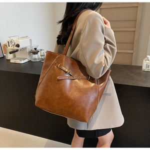 Borsa tote vintage marrone in ecopelle con dettagli dorati in un ambiente da caffetteria