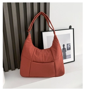 Detail of caramel nylon crescent hobo bag with wide strap and minimalist stitching