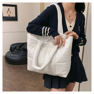 Détail des grands motifs de matelassage carrés sur un sac à bandoulière en nylon blanc