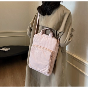 Detailansicht der rosa Stofftasche mit großer Reißverschlusstasche am beigen Trenchcoat