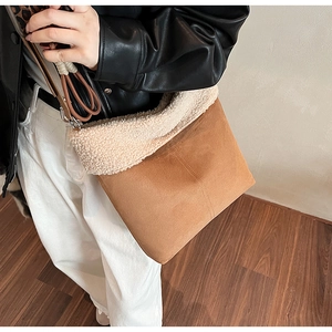 Detailed view of brown suede crossbody bag featuring soft faux shearling trim and leopard strap