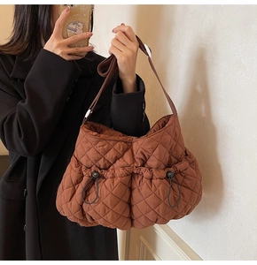 Detailed macro view of caramel brown quilted nylon bag with drawstring pocket detail