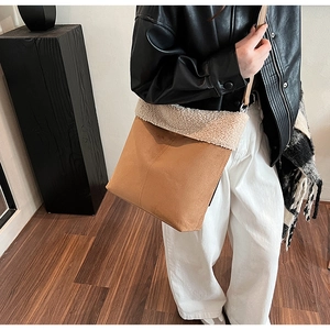Detail showing plush faux shearling trim and brown suede texture on a crossbody bag