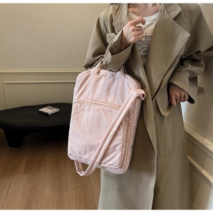 Detailansicht der rosa gesteppten Laptoptasche aus Stoff, getragen von einem Model