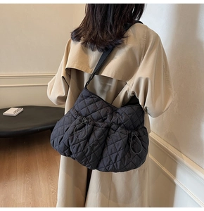 Detail of a black quilted cloud bag showing the soft texture and drawstring design