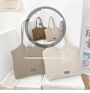 Detail showing heart quilted tote bags in coffee and cream with soft shoulder straps