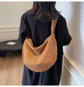 Sac hobo tendance imprimé léopard avec large bandoulière porté sur l'épaule du mannequin