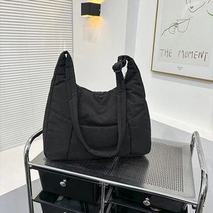 Large black quilted dumpling crossbody bag made of lightweight nylon for daily commuting