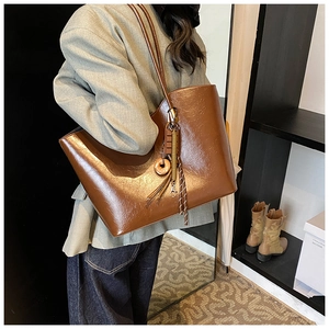 Vue détaillée du sac cabas en similicuir marron foncé avec finition cirée vintage et glands