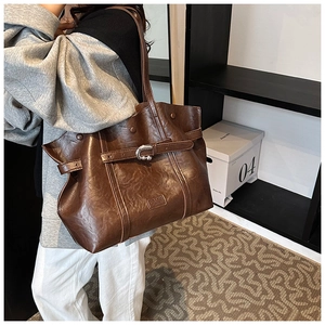 Dettaglio della borsa tote grande in pelle PU marrone scuro con fibbia argentata su modella