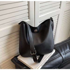 Close-up of black litchi pattern PU leather shoulder bag with vintage silver metal buckle