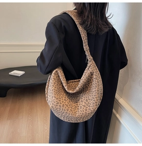 Détail d'un grand sac hobo à imprimé léopard porté par un mannequin en style décontracté