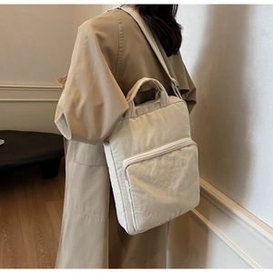 Minimalistischer beiger Stoffrucksack am Modell in natürlicher Lichtumgebung
