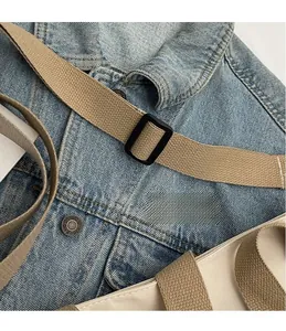 Detail of adjustable khaki canvas shoulder strap with a matte black metal buckle