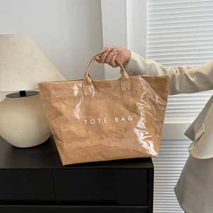 Detail view of the brown DuPont paper tote bag with waterproof layer and TOTE BAG print