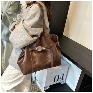 Dettaglio borsa tote marrone in pelle sintetica con trama vintage e fibbia d'argento