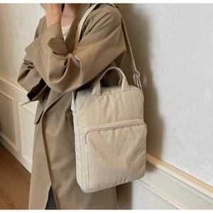 Details der minimalistischen beigen Stepptasche kombiniert mit einem khakifarbenen Trenchcoat