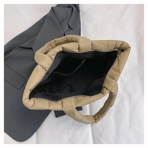 Vue détaillée du sac matelassé kaki montrant la doublure noire et la poche zippée