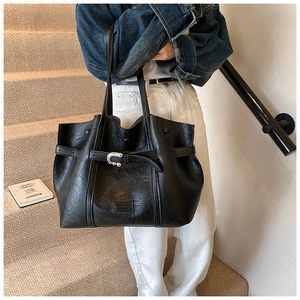 Dettaglio della grande borsa tote in pelle PU nera con fibbia in metallo ed etichetta
