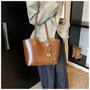 Détail du sac cabas marron en cuir PU vintage avec des breloques décoratives