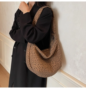 Détail d'un grand sac hobo à imprimé léopard avec large bandoulière sur un modèle
