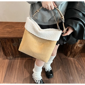 Detail of plush white faux fur and beige suede crossbody bag with silver buckles