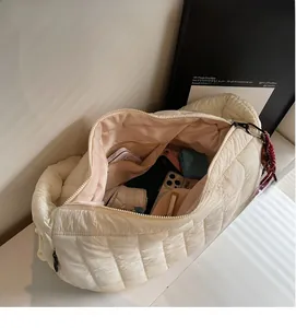 Macro view of the beige quilted crossbody bag showing spacious interior and zipper pocket