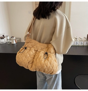 Detailed back view of a yellow quilted cloud bag with black drawstrings and wide strap