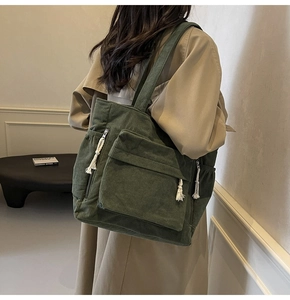 Détail du sac cabas en velours côtelé vert avec poches extérieures et tirettes tissées