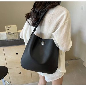 Chic black PU leather hobo bag with silver medallion shown in a lifestyle setting