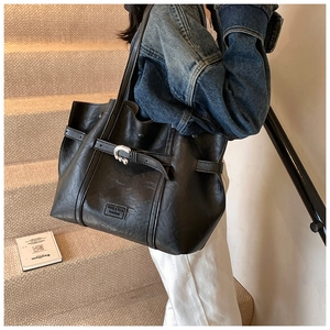 Vista dettagliata della borsa tote nera in pelle PU con fibbia argento ed etichetta