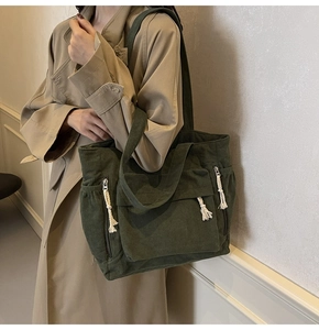 Détail du sac fourre-tout en velours côtelé vert foncé avec poches sur trench kaki