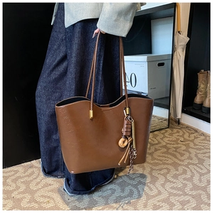 Détail d'un sac cabas en PU marron vintage avec bandoulière et bijou de sac donut