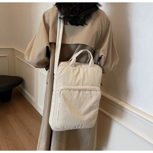 Detailansicht der cremeweißen Nylon-Laptoptasche mit Reißverschlussfach und Gurt