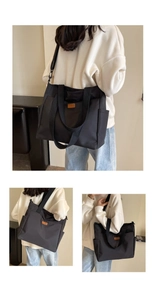 Detail of black nylon tote bag with leather tag, showing side pockets and dual handles