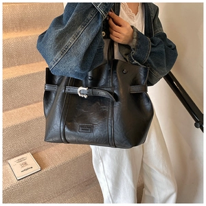 Dettaglio della borsa a spalla in pelle PU nera con fibbia e finitura vintage testurizzata