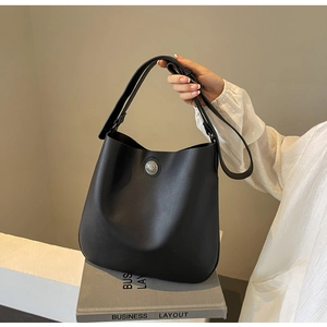 Detailed view of black PU leather bucket bag with vintage silver buckle and wide strap