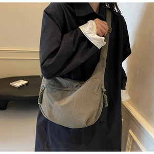 Detail of adjustable strap and zipper with woven puller on olive green nylon crescent bag