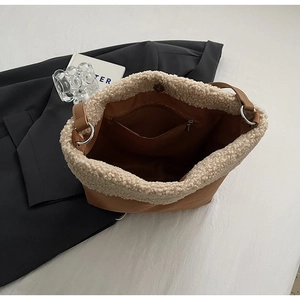 Detail view of brown tote bag featuring fleece trim, inner zipper pocket and leather straps
