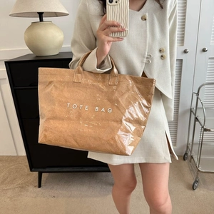 Detailed close-up of double-layer tote bag featuring transparent PVC and paper texture