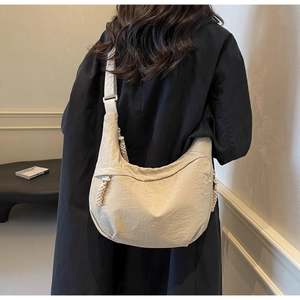 Detailed back view of a beige nylon dumpling bag showing large capacity and drape