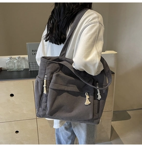 Gros plan d'un sac cabas en velours côtelé gris foncé avec détails de poche frontale