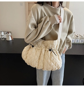 Detail of quilted dumpling bag showing the puffy nylon texture and adjustable drawstring