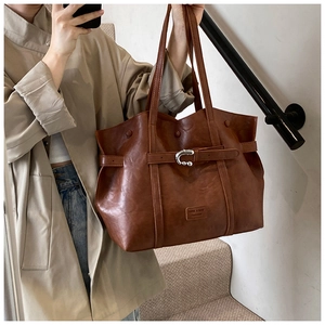 Dettaglio della borsa tote in pelle PU marrone con fibbia a ferro di cavallo argentata