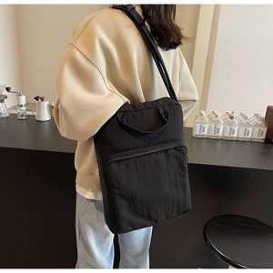 Detailansicht der schwarzen Nylon-Umhängetasche mit breitem Gurt und großer Reißverschlusstasche