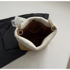 Detail view of the plush suede tote interior with a zipper pocket and fluffy trim finish