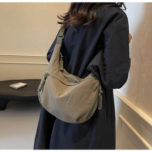 Detail view of khaki nylon dumpling bag showing large capacity and adjustable wide strap